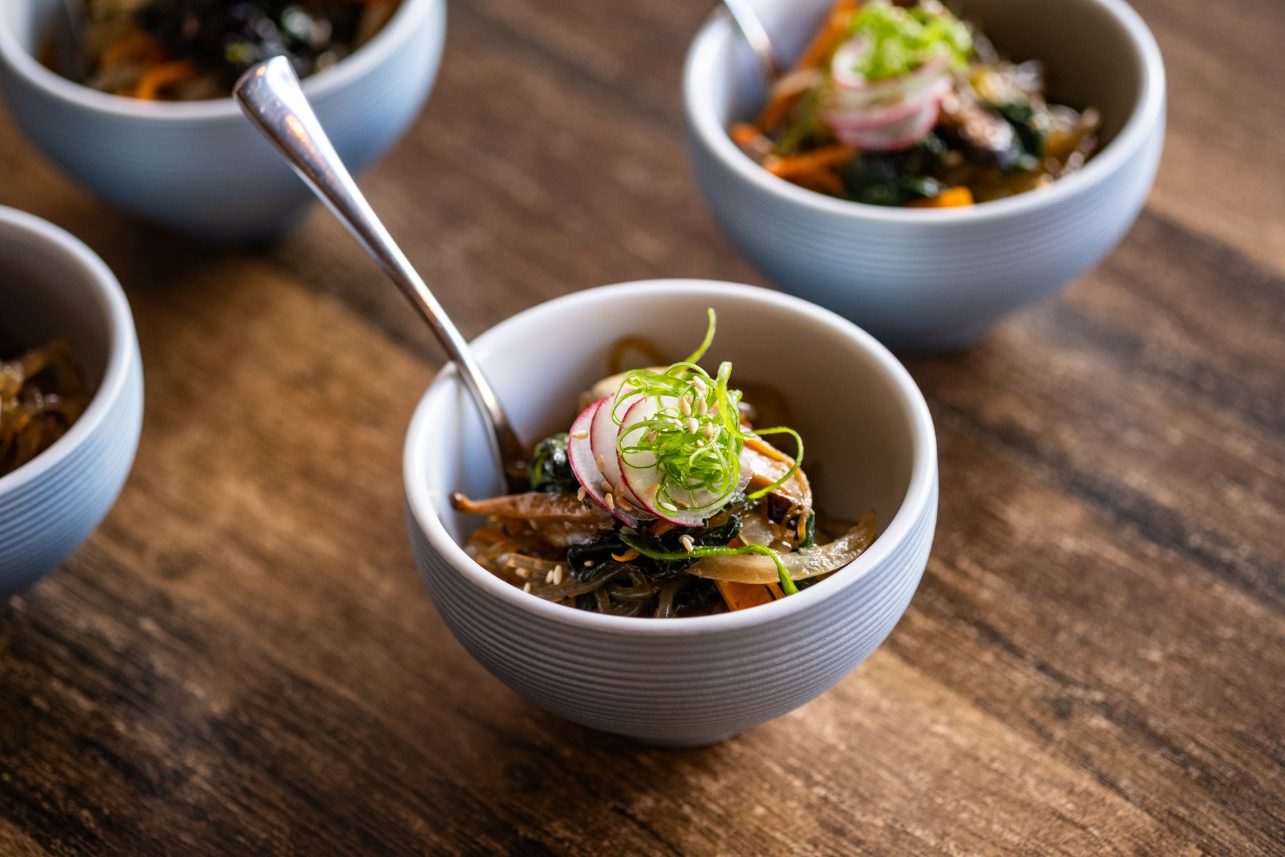 Japchae served in an individual ceramic bowl