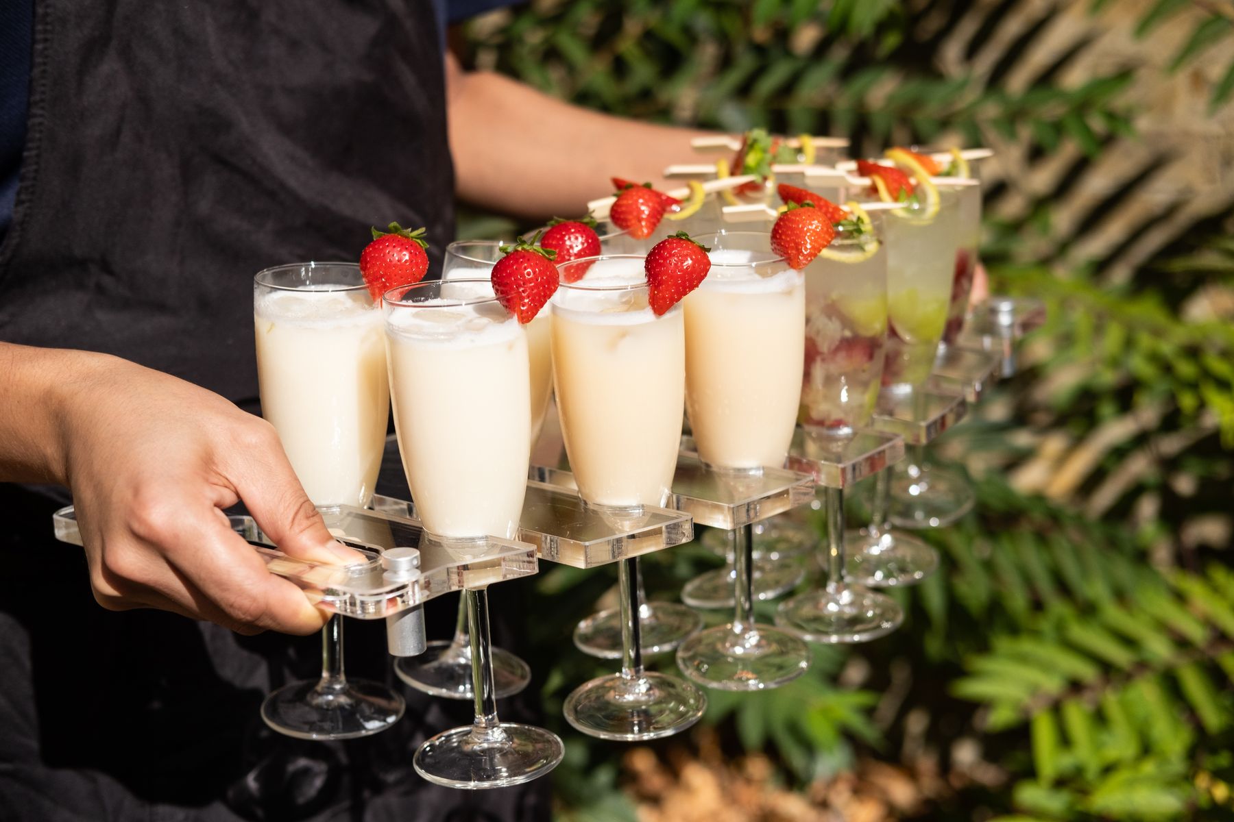 Staff carrying a tray of drinks outdoors