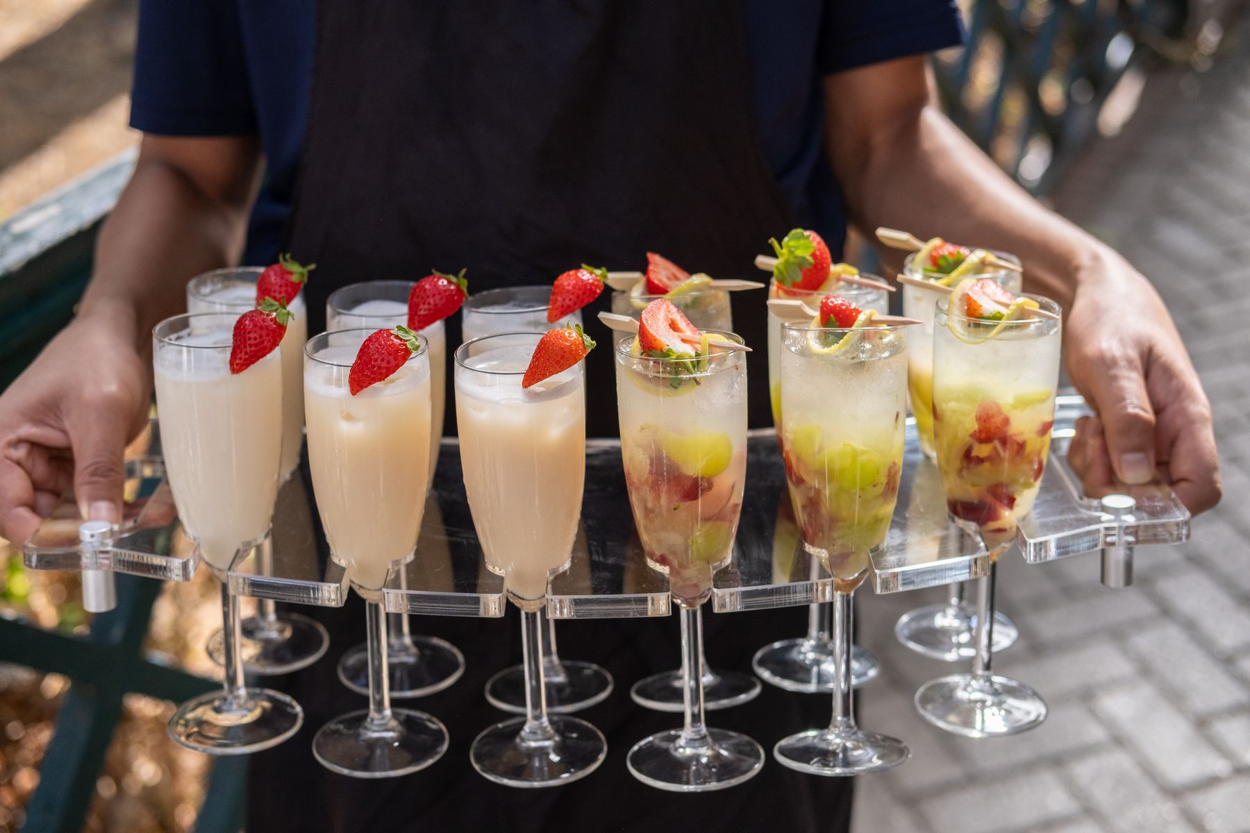 Staff carrying a tray of garnished drinks