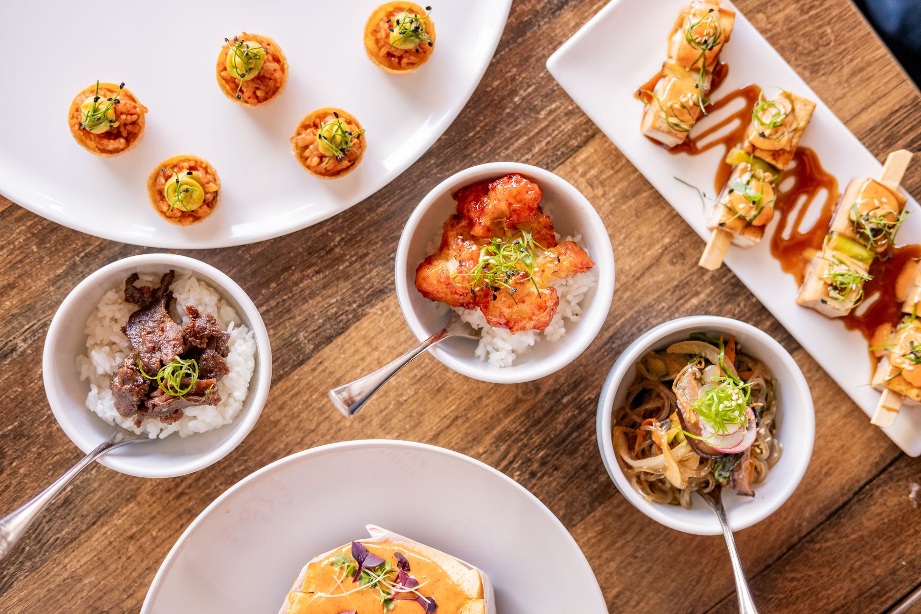 Overhead spread of canapés, bowl food and skewers